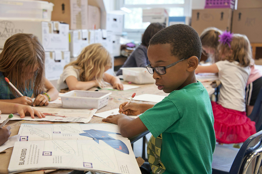 Elementary aged students work at a table in a classroom