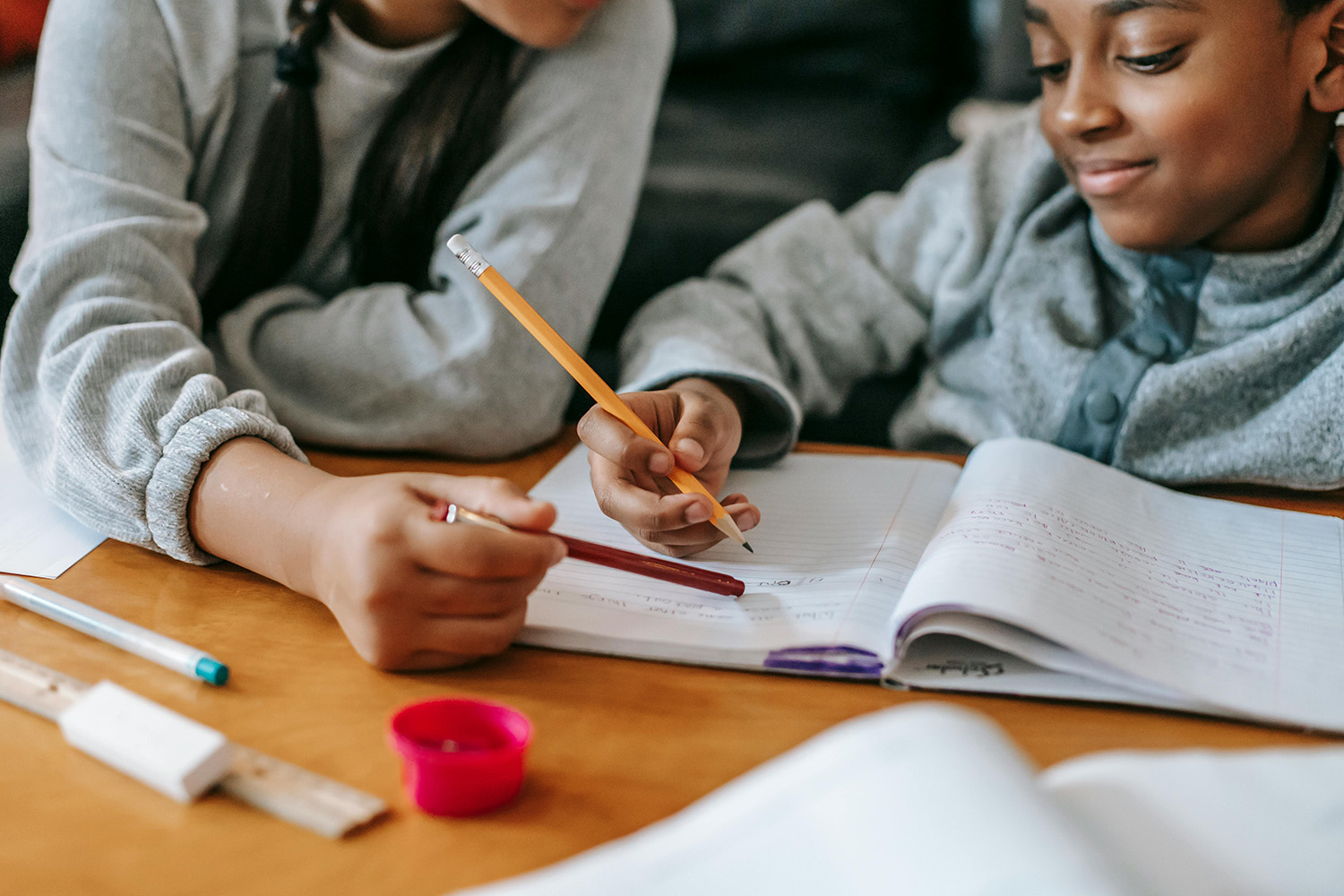 A child sits at a table writing in a notebook